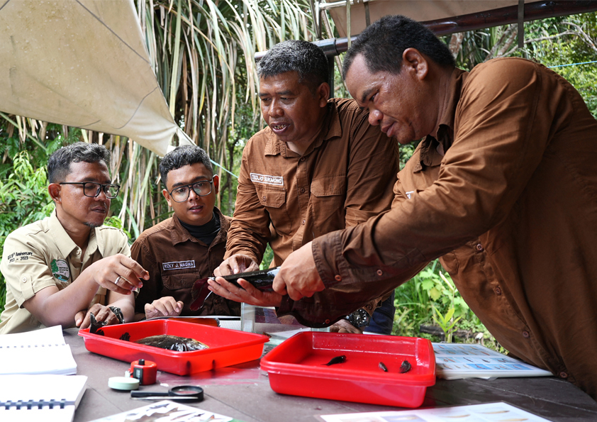 Fish researchers identifying samples at a remote guard post in the RER landscape